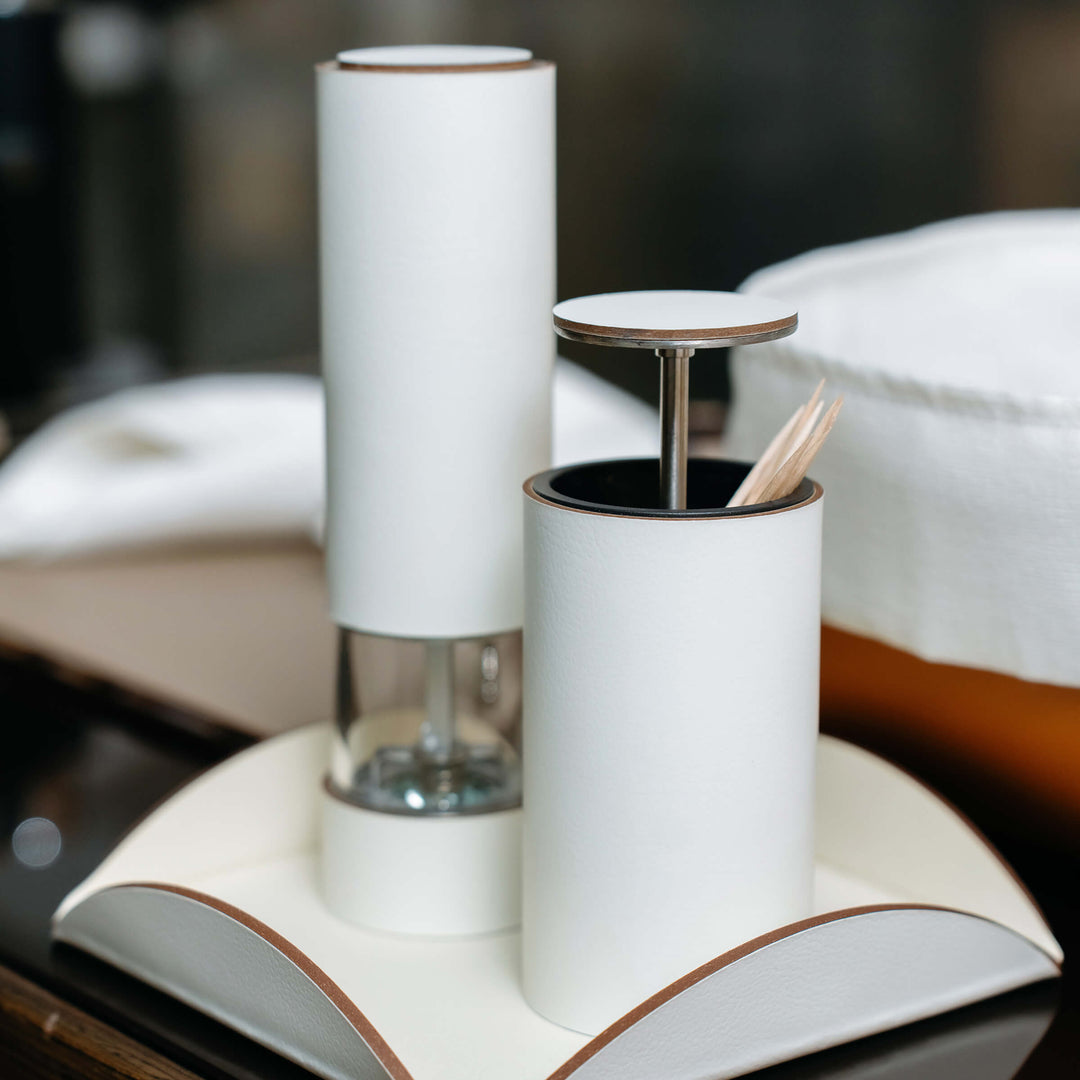 White salt and pepper shakers on a wooden surface with a blurred background