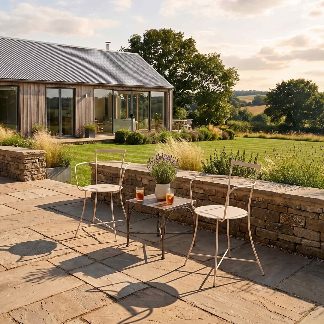 white armchairs irma by internoitaliano in a patio next to a garden