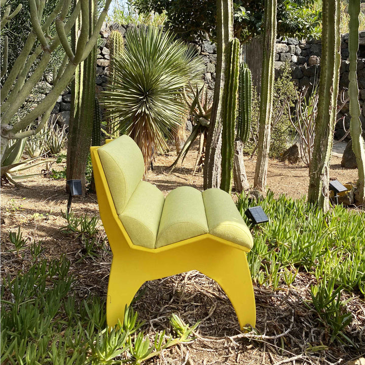 Calder Yellow chair by Jules Regis, bright yellow structure with soft cushions, contemporary designer seating in a garden
